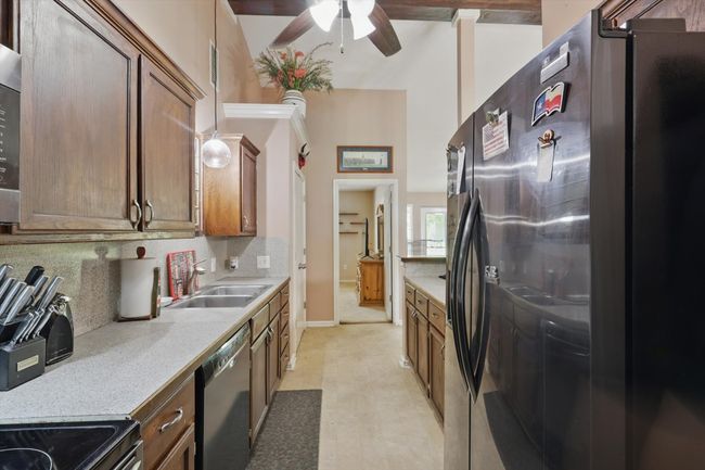 Kitchen featuring tasteful backsplash, a sink, dishwasher, ceiling fan, and freestanding refrigerator | Image 14