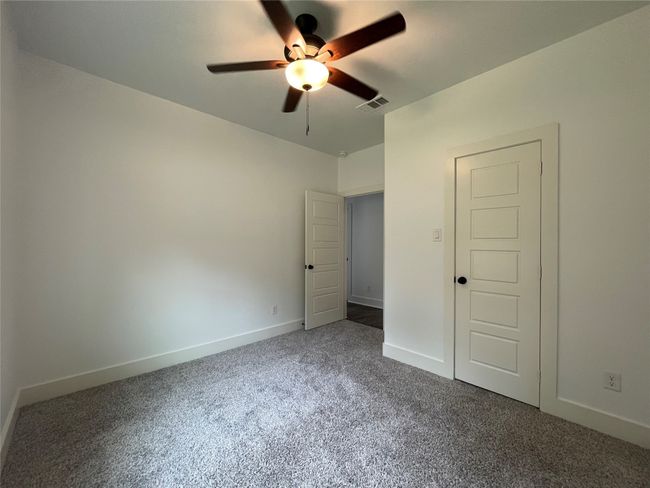 Unfurnished bedroom featuring dark carpet, baseboards, and a ceiling fan | Image 32