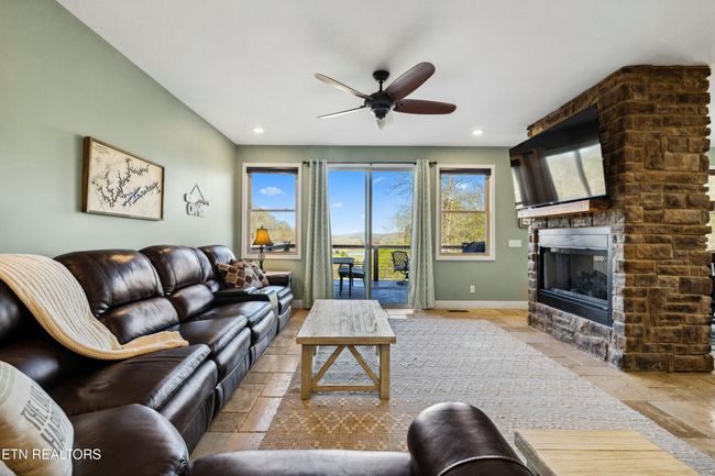 Wonderful view and deck access for outdoor enjoyment. Two sided propane fireplace. | Image 10