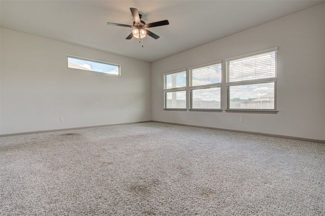 Unfurnished room with carpet floors, baseboards, and a ceiling fan | Image 16