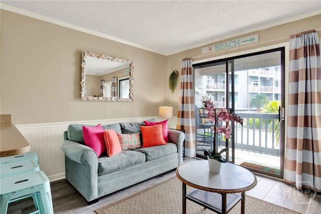 Open Living Area with Sleeper Sofa & Plenty of Natural Light Plus Access to Private Outdoor Balcony with Sunset & Partial Water Views! | Image 6