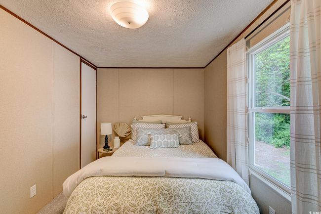 Bedroom featuring a decorative wall and a textured ceiling | Image 24