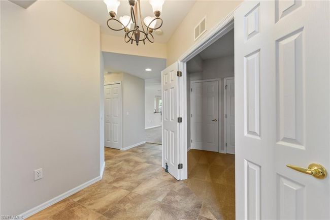 Corridor with an inviting chandelier, baseboards, and visible vents | Image 9