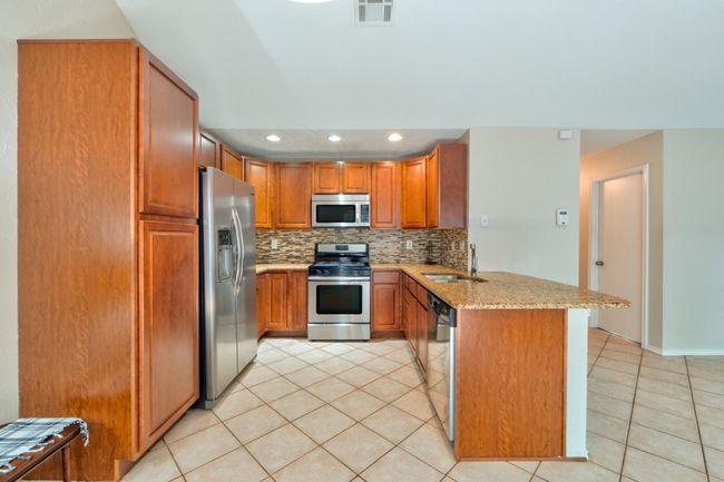 Kitchen featuring a peninsula, stainless steel appliances, and plenty of storage to house your wares. | Image 10