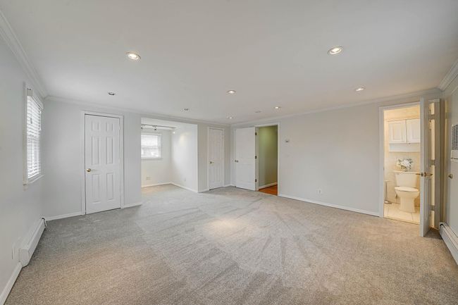 Carpeted spare room featuring baseboard heating and crown molding | Image 22