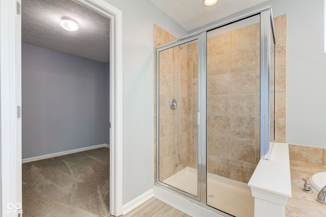 full bathroom with a shower stall and a textured ceiling | Image 35