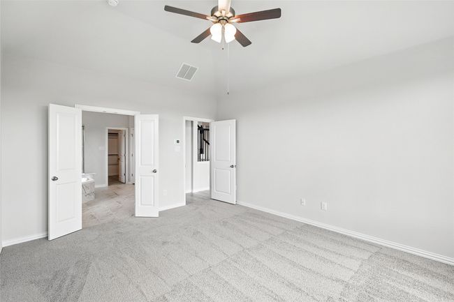 Unfurnished bedroom with light carpet, high vaulted ceiling, and a ceiling fan | Image 16