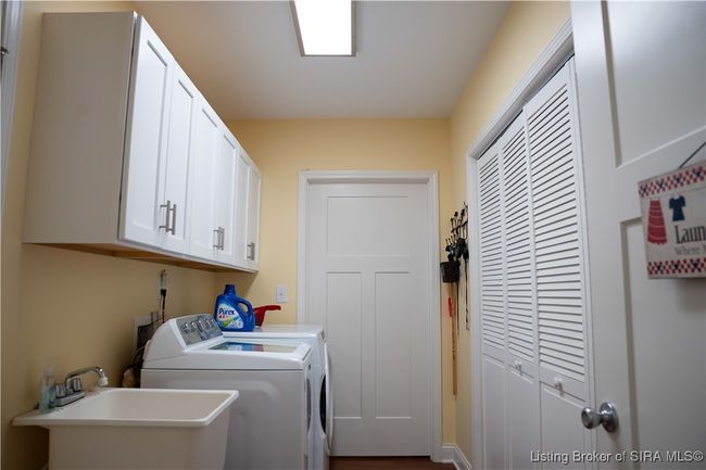 Laundry room with laundry sink and added cabinets. | Image 43
