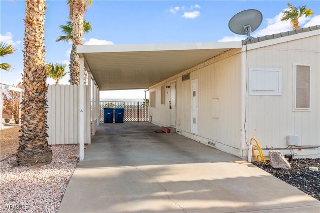 View of carport parking with driveway, an attached carport, and fence | Image 29