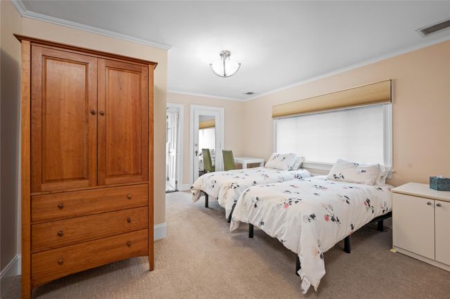 Bedroom featuring light carpet, visible vents, and ornamental molding | Image 19
