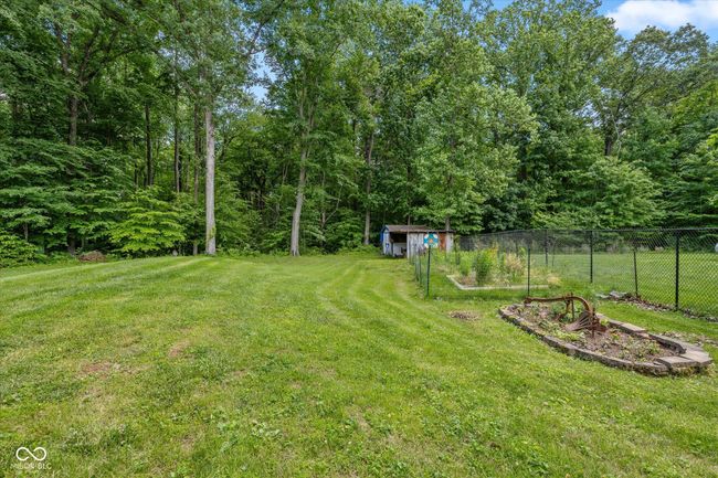 A mini barn with a lean to is included as are the raised flower beds. | Image 31