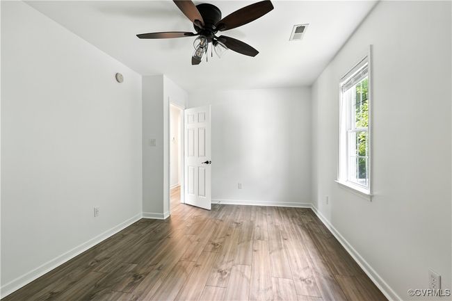 Another view of 3rd bedroom with Laminate style floors and a ceiling fan | Image 24