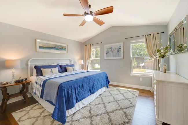 Bedroom featuring wood finished floors, lofted ceiling, and a ceiling fan | Image 30
