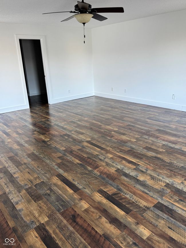 spare room with baseboards, dark wood-style floors, and ceiling fan | Image 10