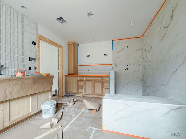 Primary en-suite bathroom will be beautifully designed with white oak cabinetry, freestanding tub, designer lighting, floaitng shelving, Moen plumbing fixtures, 24x48 tile grand shower walls with large frameless shower doors, and an added lavatory with storage cabinets. | Image 18
