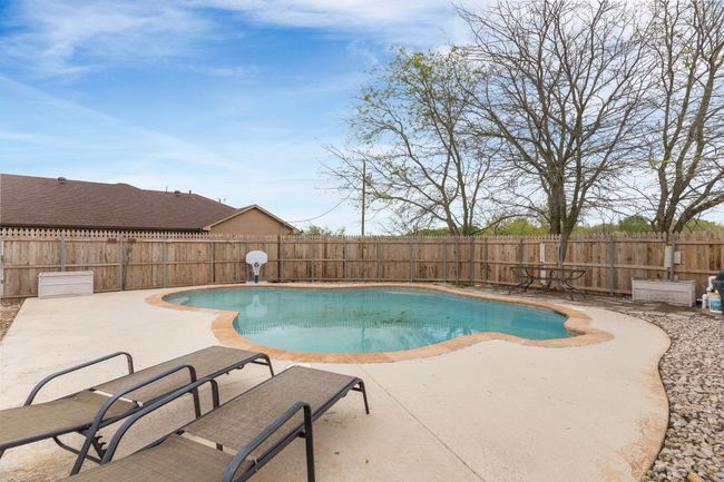 View of pool with a patio area, a fenced backyard, and a fenced in pool | Image 9