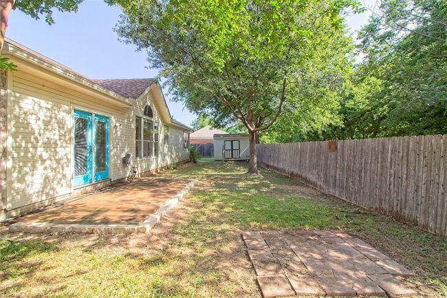 Fenced backyard with a patio and a storage shed | Image 31