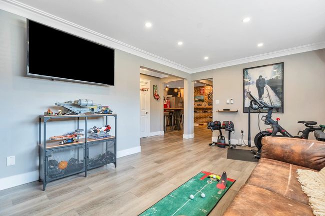 Living room with crown molding, light wood-style flooring, recessed lighting, and baseboards | Image 9