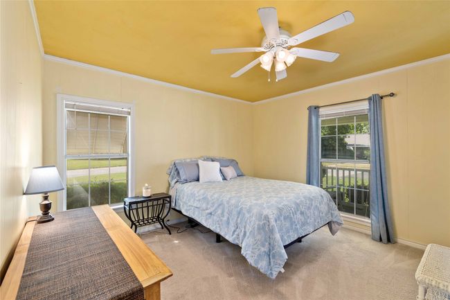 Front bedroom with windows showcasing front and side yard. | Image 24