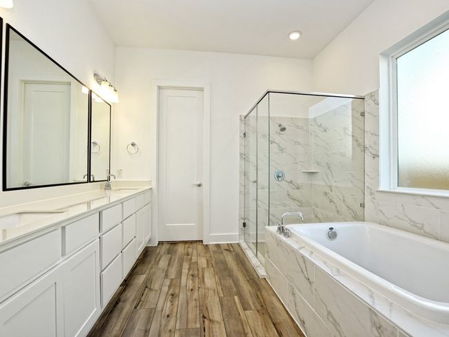 Full bath with a garden tub, a marble finish shower, double vanity, and wood finished floors | Image 19