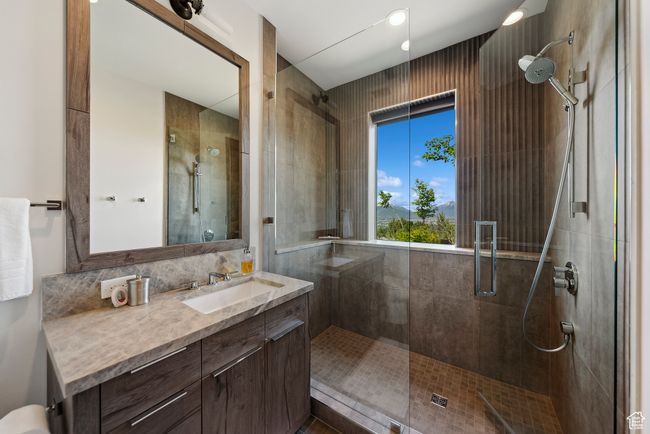 Bathroom featuring a stall shower and vanity | Image 98