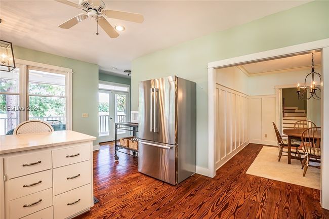 Kitchen with white cabinets, dark hardwood / wood-style floors, pendant lighting, and stainless steel fridge | Image 20