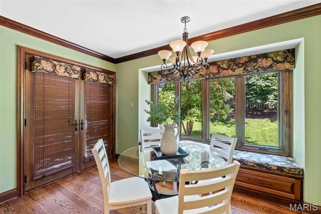 Dining space featuring a chandelier, french doors, wood finished floors, and ornamental molding | Image 15