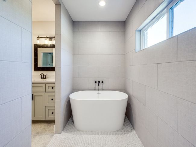 Elegant stand-alone tub with wall mounted hardware is tucked in the cozy south recess of the walk-in shower. | Image 18