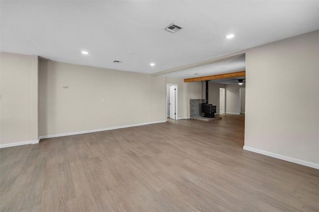 Unfurnished living room with light hardwood / wood-style flooring and a wood stove | Image 18