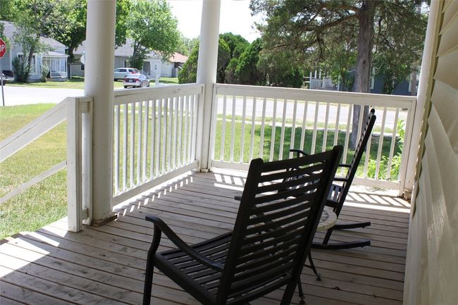 Wooden deck featuring covered porch, a yard, and a residential view | Image 7