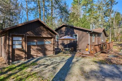 View of front of property with an outdoor structure, a garage, and a deck | Image 2