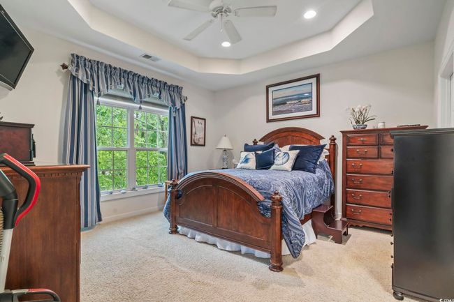 Carpeted bedroom with a raised ceiling, recessed lighting, and ceiling fan | Image 9