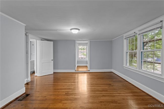 Spare room with ornamental molding, wood finished floors, visible vents, and baseboards | Image 24
