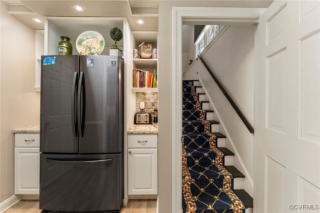 Kitchen with light stone counters, recessed lighting, white cabinets, and freestanding refrigerator | Image 24