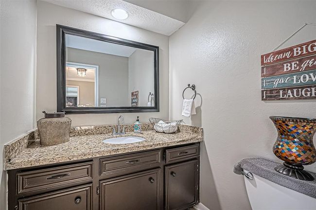 Convenient downstairs half bath with granite countertop. | Image 23