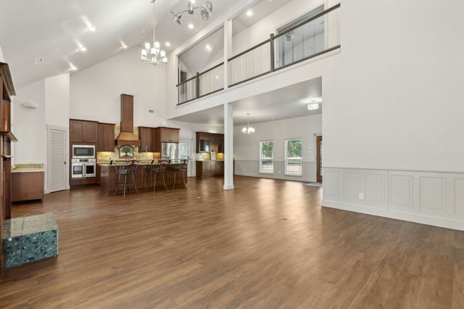 Living room featuring high vaulted ceiling, dark hardwood / wood-style flooring, and a chandelier | Image 12