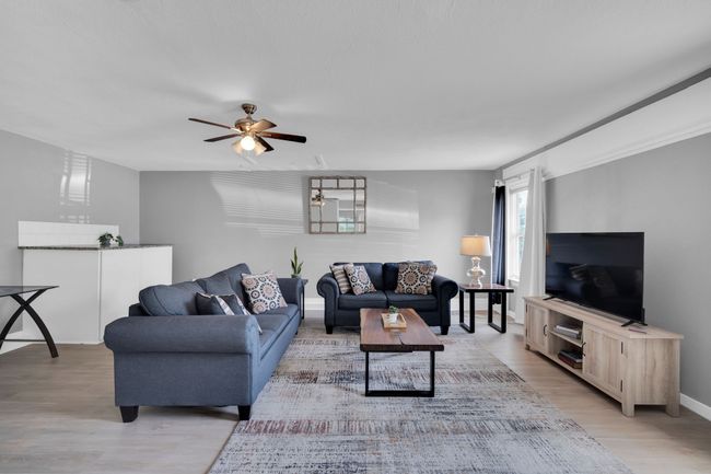 Living area featuring baseboards, ceiling fan, and light wood-type flooring | Image 11