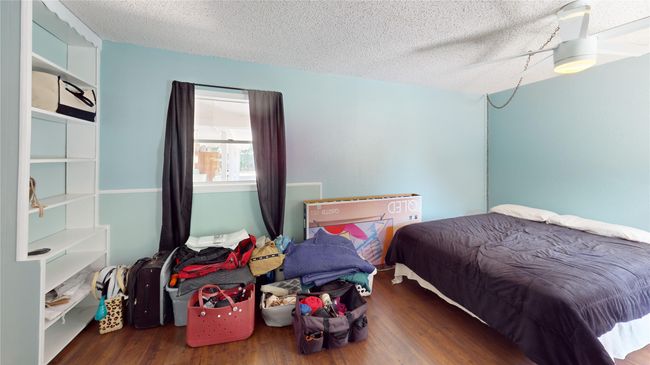 Bedroom with wood finished floors and a textured ceiling | Image 20