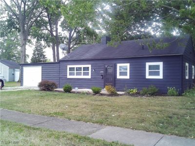 Ranch-style home with a garage and a front lawn | Image 2