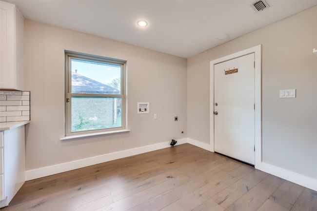 Laundry area featuring hookup for an electric dryer, light wood finished floors, hookup for a washing machine, and recessed lighting | Image 12