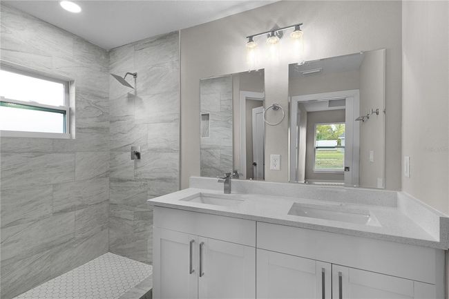 Primary bathroom with double sinks and tiled shower | Image 24