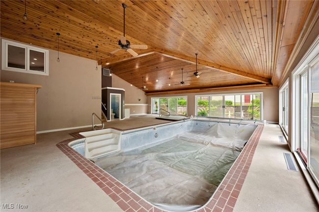 View of swimming pool with a hot tub, sauna, and ceiling fan | Image 36