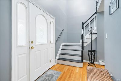 An inviting entryway showcases hardwood floors and a staircase leading to the second level. | Image 3