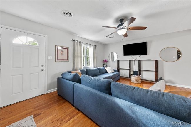 Living area featuring visible vents, ceiling fan, light wood-style flooring, and baseboards | Image 9