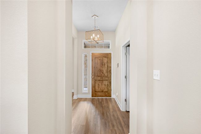 Entryway with a chandelier, wood finished floors, and baseboards | Image 10