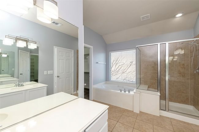 Full bath featuring a spacious closet, a stall shower, visible vents, and tile patterned floors | Image 33