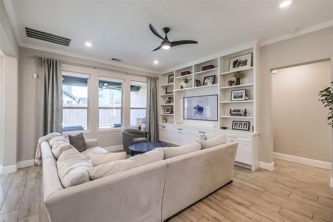 CUSTOM BUILT SHELVES and cabinetry elevate the living room and provide lots of storage. | Image 11