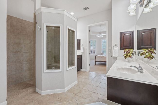 Full bathroom with double vanity, ensuite bathroom, walk in shower, and ceiling fan | Image 13