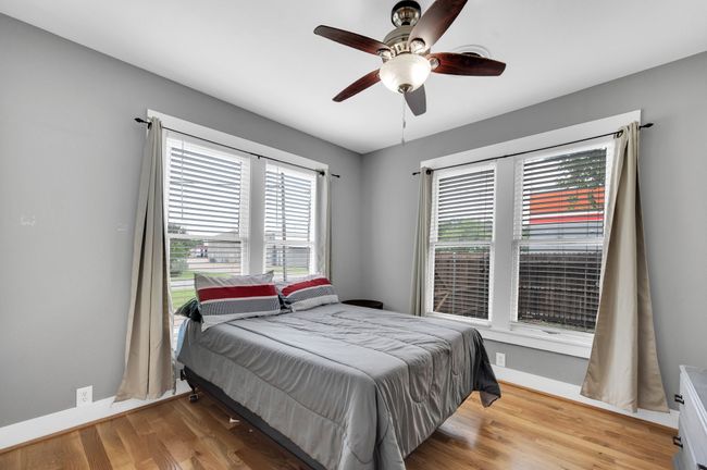Bedroom with light wood-type flooring, a ceiling fan, and baseboards | Image 11