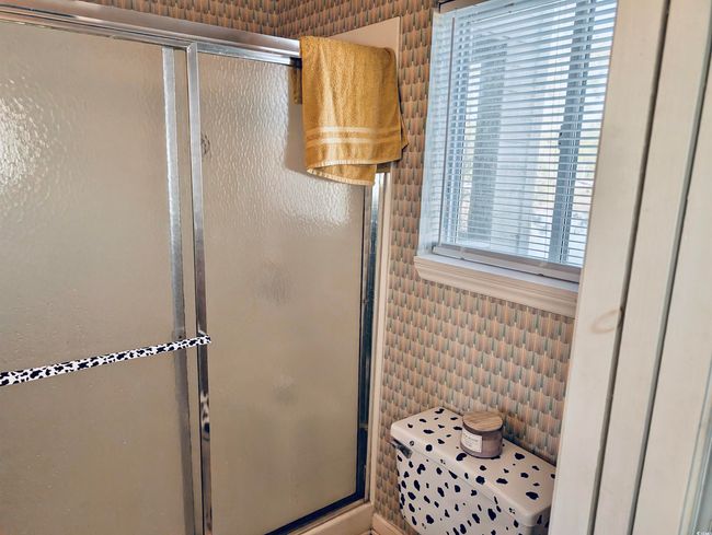 Bathroom featuring a shower with door and tile walls | Image 12